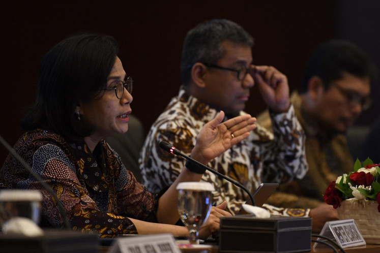 Finance Minister Sri Mulyani Indrawati (left) and Deputy Finance Minister Suahasil Nazara (center) gesture during a press briefing on the realization of the 2020 State Budget and Expenditure (APBN) in Jakarta on Feb. 19. 