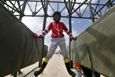 On his mark: Ari, a small jockey, is preparing to ride his horse. This 14-year-old jockey, who started his career last year, is respected by his opponents. JP/Hotli Simanjuntak