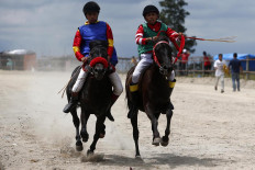 Head to head: Ari (right) paces his horse to get to the finish line before his opponent does. JP/Hotli Simanjuntak