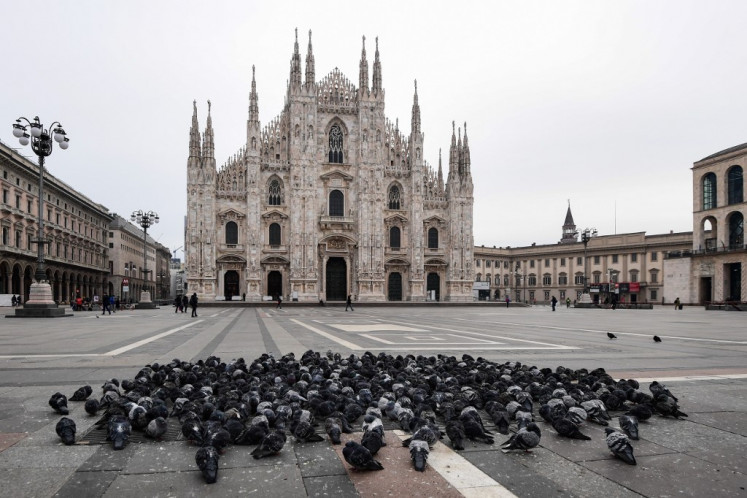 Pigeons gather on Piazza del Duomo by Milan's cathedral on March 10, 2020 in Milan. - Italy imposed unprecedented national restrictions on its 60 million people on March 10, 2020 to control the deadly coronavirus, as China signalled major progress in its own battle against the global epidemic. 
