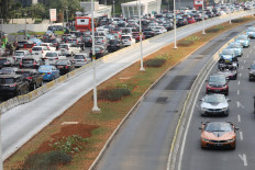 Jakarta Governor Anies Baswedan drives an orange BMW i8 Roadster to lead a convoy of electric vehicles from Gelora Bung Karno Stadium toward the National Monument in Jakarta on Sept. 20, 2019.