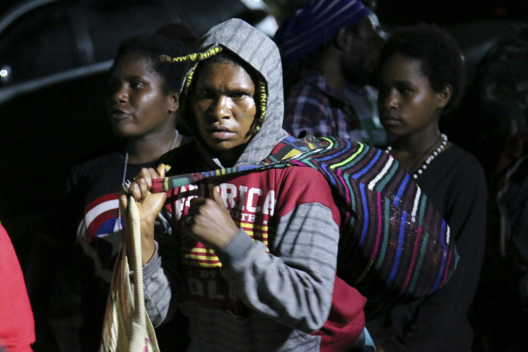 Residents of Tembagapura district in Mimika regency, Papua waits to be evacuated by the Indonesian Military (TNI) and the National Police personnel on March 8, 2020. Thousands of residents in the area have been displaced from their homes due to armed conflict between security forces and armed criminal groups.