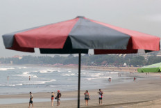 Beachgoers visit a relatively empty Kuta Beach on March 3, 2020 in Bali. The island reopened to international travel last October,  but only welcomed the first international flight this February.