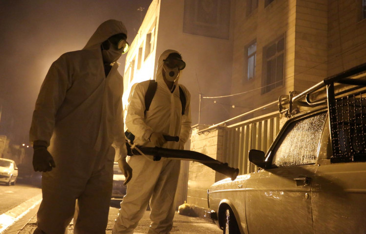 Iranian firefighters disinfect streets in southern Tehran to halt the wild spread of coronavirus on March 11, 2020. - The novel coronavirus outbreak in Iran is one of the deadliest outside of China and has so far killed 291 people and infected more than 8,000. 