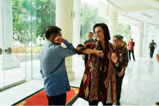 Finance Minister Sri Mulyani Indrawati (right) and fomer vice president Jusuf Kalla greet each other with an elbow bump at the Vice Presidential office on March 12 in Jakarta.