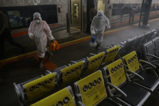 Officers spray disinfectant at Gambir train station, Jakarta, on Thursday.