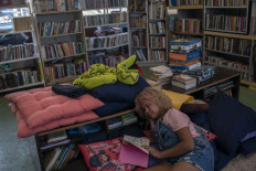 Brazilian Lua Oliveira, 12, reads a book at the public library Mundo da Lua (Lua's World), founded by her five months ago, at the Tabajaras favela in Rio de Janeiro, Brazil, on March 10, 2020. 