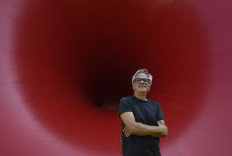 British contemporary artist Anish Kapoor stands in front of his artwork 'Sectional body preparing for Monadic Singularity' during the opening of his exhibition entitled 'Works, thoughts, experiments' at the Serralves Foundation in Porto, on July 6, 2018.
