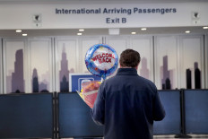 Travelers arrive at the international terminal of O'Hare Airport on March 13 in Chicago, Illinois.