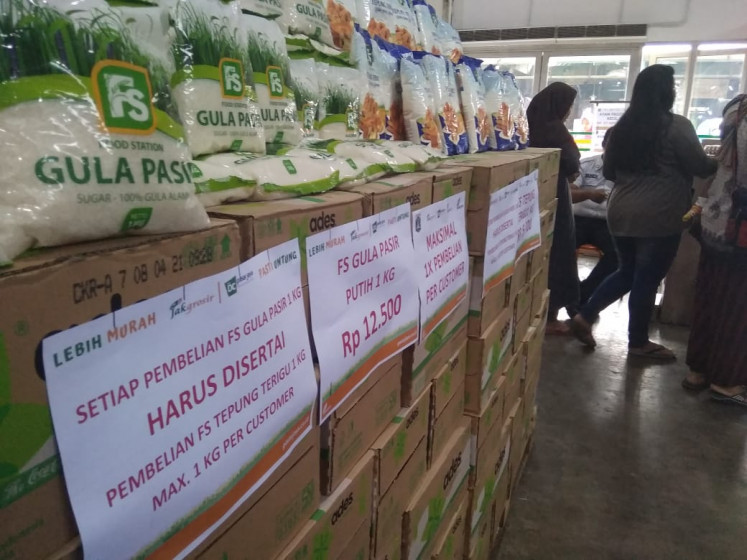 Customers shop at wholesale food market Jakgrosir in Jakarta on March 12 in front of a sign that says 