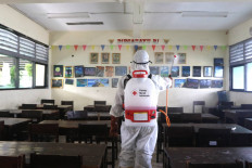 Indonesian Red Cross (PMI) officers in Central Jakarta prepare to spray disinfectant in a school in Jakarta on March 3, 2020.