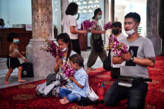 Thais return to temples in traditional garb, and masks