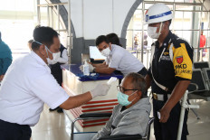 An officer at Pasar Senen Train Station, Central Jakarta on Monday, March 16, 2020 checks the temperature of a long-distance railway passenger before entering the Station's waiting room. Some people go home or go home even though there is already an appeal to be better at home than to travel and gather in a crowd. 