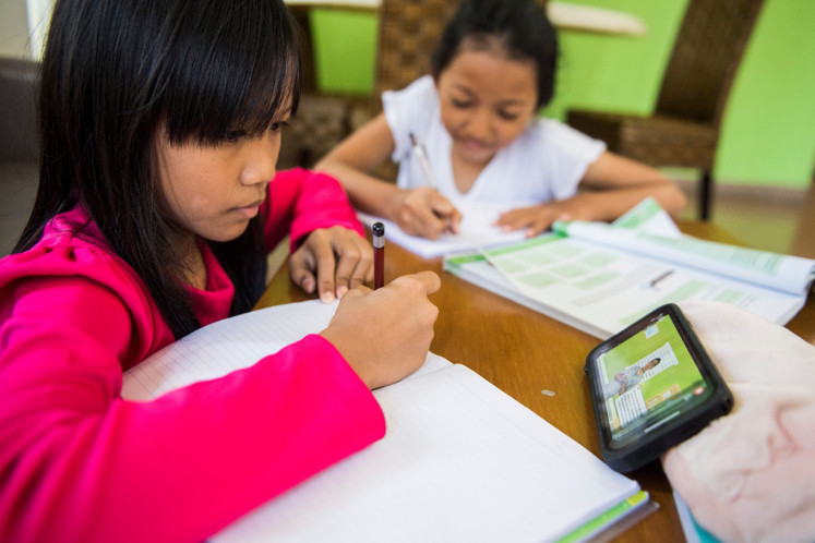 Two children watch digital learning videos from home in Bandung, West Java, on March 17, 2020.