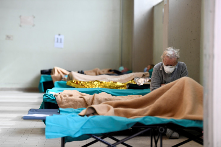 A patient is seen sitting inside the Spedali Civili hospital in Brescia, Italy March 13, 2020.  