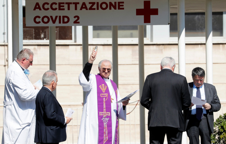 A priest blesses the Columbus Clinic, where patients suffering from coronavirus disease (COVID-19) were moved from Spallanzani Hospital, in Rome, Italy March 16, 2020.
