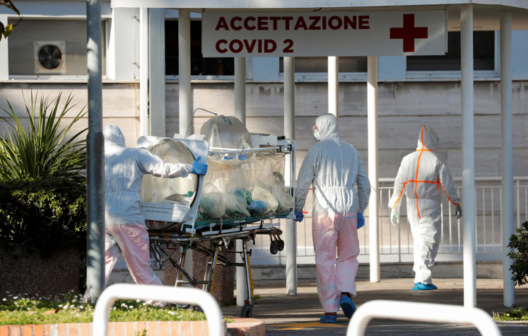 Medical workers in protective suits push an isolation stretcher in front of the Columbus Clinic, where patients suffering from coronavirus disease (COVID-19) were moved from Spallanzani Hospital, in Rome, Italy March 16, 2020.  