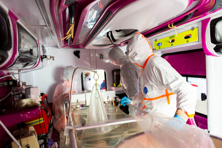 Medical workers in protective suits monitor a coronavirus patient who is being transferred in an ambulance from the intensive care unit of the Gemelli Hospital to the Columbus Covid Hospital, which has been assigned as one of the new coronavirus treatment hospitals in Rome, Italy, March 16, 2020.