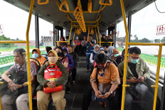 Passengers wearing face masks ride a Transjakarta bus on Wednesday. The number of public transportation passengers, especially in Jakarta, has significantly dropped by up to 70 percent amid the COVID-19 pandemic.