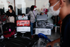 Passengers wearing masks stand by with their luggage outside the Ninoy Aquino International Airport in Paranaque, Metro Manila, amid fears of coronavirus disease (COVID-19) spreading in Philippines, March 18, 2020. 