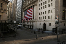 A pedestrian walks on Wall St., as concerns about coronavirus disease (COVID-19) keep more people at home, in front of the New York Stock Exchange (NYSE) in New York, U.S., March 18, 2020. 