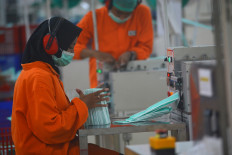 Workers produce surgical masks on March 18, 2020, at a factory belonging to PT Jayamas Medica Industri in Jombang regency, East Java.