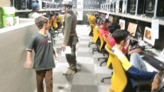 A Jakarta Public Order Agency officer visits an internet cafe in Jakarta on Tuesday. The agency is conducting raids to ensure students don’t visit internet cafes to play games during the city-imposed curfew and school closure to curb the spread of the coronavirus.