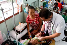 A doctor checks an infant diagnosed with dengue fever on March 10, 2020 at T.C. Hillers General Regional Hospital in Maumere, Sikka regency, East Nusa Tenggara.
