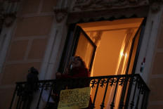 Spanish blues singer Beatriz Berodia 'Betta' sings from her balcony during a daily evening concert to support health workers and to make it easier for her neighbors to bear the coronavirus lockdown in Madrid, Spain, on March 19, 2020.