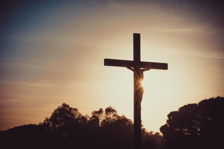 This artist's rendering shows Jesus Christ crucified on Calvary Hill, silhouetted against the sunset.