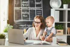 A mother runs her business from home while caring for her toddler.