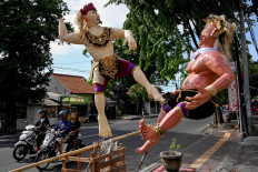 Motorcyclists pass effigies known as Ogoh-Ogoh ahead of the Day of Silence in Denpasar, Bali, on March 24, 2020. 