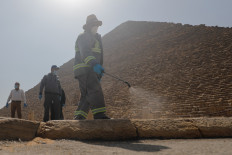A member of the medical team sprays disinfectant as a precautionary move amid concerns over the coronavirus disease (COVID-19) outbreak at the Great Pyramids, Giza, on the outskirts of Cairo, Egypt, on March 25, 2020. 