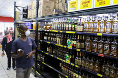 A shopper wearing a protective mask shops for liquor ahead of a nationwide lockdown for 21 days to try to contain the coronavirus disease (COVID-19) outbreak, in Johannesburg, South Africa, March 26, 2020. 