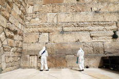 Workers in hazmat suits collect prayers from "God's mailbox" in Jerusalem