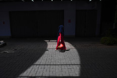 A woman walks past a row of closed shops in Pasar Baru, Jakarta, on April 1.