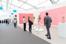Visitors observe art by Takashi Murakami at the New York Frieze Art Fair in New York on May 3, 2018. 