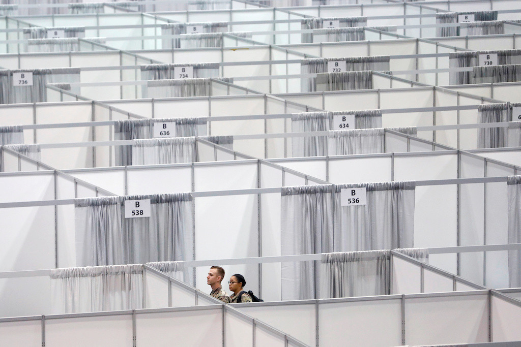 Military personnel walk among cubicles being prepared as part of phase 2 of the Javits New York Medical Station at the Jacob K. Javits Convention Center during the coronavirus disease (COVID-19) outbreak in Manhattan, New York City, United States., April 3, 2020. 