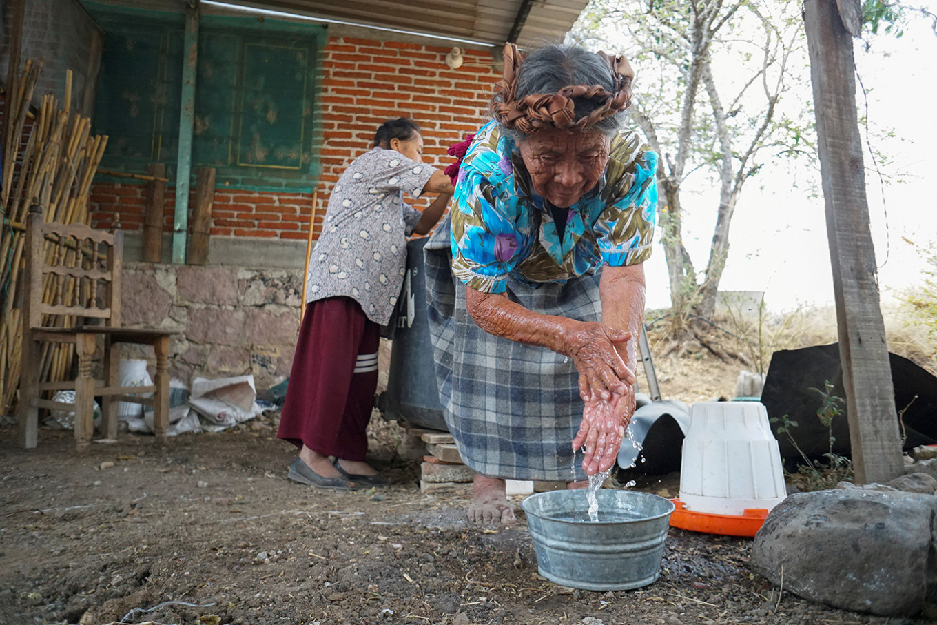Zapotec woman Juana Lazaro, a non-Spanish-speaker, washes her hands after learning about hand-washing and social distancing to avoid coronavirus disease (COVID-19) from a local radio program, at her house in Teotitlan del Valle, in Oaxaca state, Mexico March 31, 2020. Picture taken March 31, 2020. 