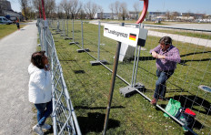 A German sign reads 'National border' in between two fences built by Swiss and German authorities on the German-Swiss border as a protection measure due to the spread of the coronavirus disease (COVID-19) in Kreuzlingen, Switzerland April 5, 2020. 