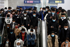 People wearing face masks stand on an escalator inside a subway station during morning rush hour in Beijing, as the spread of the novel coronavirus disease (COVID-19) continues in the country, in China April 7, 2020. 
