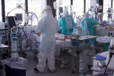 Healthcare workers wearing protective suits attend to COVID-19 coronavirus patients at the Intensive Unit Care (ICU) of the Vall d'Hebron Hospital in Barcelona on April 6, 2020.