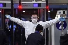 A man wearing protective gear gets through security check at Wuchang Railway Station before travel restrictions to leave Wuhan, the capital of Hubei province and China's epicentre of the novel coronavirus disease (COVID-19) outbreak, are lifted, April 7, 2020. 