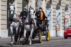 A horse-drawn carriage turns at an intersection in the 3rd district in Vienna, Austria on April 8, 2020. 