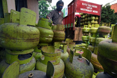 A worker unloads 3 kilogram LPG containers at a gas distribution point in Taktakan, Serang, Banten, on April 9, 2020.