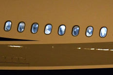 Passengers evacuated from the coronavirus-stricken Australian liner Greg Mortimer sit in the medically equipped plane that will fly Australian and New Zealander nationals to Melbourne, before departing from Carrasco International Airport early on April 11, 2020 in Ciudad de la Costa, Canelones Department, near the Uruguayan capital Montevideo. - The evacuation of 112 Australian and New Zealander passengers from the stranded cruise ship infested with the coronavirus will take place 
