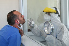 A health worker collects a swab sample from another health worker at the Istanbul University Cerrahpasa medical faculty hospital on April 10, 2020 in Istanbul.
