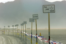 Signs are posted at the entrance of Black Rock City during the Burning Man Festival in Nevada 01 September 2000. 