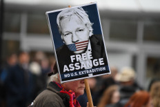 A supporter of WikiLeaks founder Julian Assange holds a placard calling for his freedom outside Woolwich Crown Court and HMP Belmarsh prison in southeast London on February 24, 2020, ahead of the opening of the trial to hear a US request for Assange's extradition. 