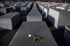 This file photo taken on Jan. 27, 2020 shows a rose lying on one of the concrete steles of the Memorial to the Murdered Jews of Europe (Holocaust memorial) in Berlin, to commemorate the 75th anniversary of the liberation by Soviet troops of the Auschwitz-Birkenau concentration camp in Poland. - From swastikas sprayed on the walls to Hitler salute selfies, far-right provocations are a growing problem at the sites of former Nazi concentration camps in Germany.